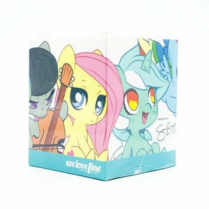 May include: A box featuring colorful cartoon pony characters. The box has a light blue base with the text "we love fine" and "FOR FANS BY FANS". The box art includes a yellow pony with pink hair, a green pony with a guitar, and other ponies.