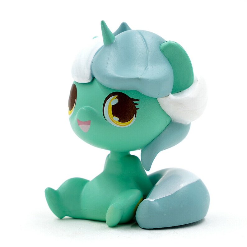 May include: A mint green figurine of a seated cartoon character with large brown eyes, yellow irises, and a smiling pink mouth. The character has a light blue helmet-like head covering, white accents, and a light blue tail.