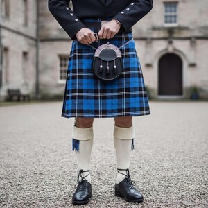 A person wearing a traditional Scottish kilt and black shoes stands in front of a stone building.