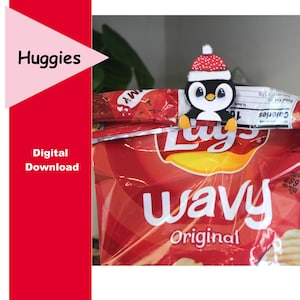 May include: A penguin-shaped chip bag clip with a red and white Santa hat, holding onto a red bag of Lay's Wavy Original chips. The image also includes the text "Huggies" and "Digital Download".