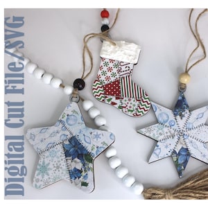 Peut inclure: Trois décorations suspendues comprenant une étoile, une chaussette et une étoile à plusieurs branches, toutes avec des motifs de style patchwork. Les ornements incluent des perles en bois blanc, de la ficelle de jute et le texte Digital Cut File/SVG.