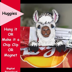May include: A wooden llama-shaped chip clip with a white body, brown face, and black and white feet, holding onto a red and yellow chip bag. The image includes the text "Huggies" and "Hang it OR Make it a Chip Clip OR Magnet."