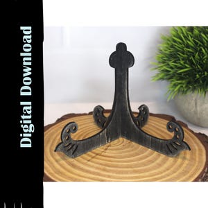 May include: A dark gray wooden display stand with a decorative design. The stand is on a wooden slice, and the text "Digital Download" is on the left side of the image.
