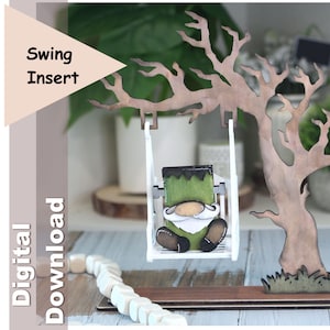 Könnte beinhalten: Ein hölzerner Schaukeleinsatz mit einem als Frankenstein verkleideten Zwerg. Der Zwerg sitzt in einer weißen Schaukel, die an einem Baum aus Holz befestigt ist. Die Wörter "Swing Insert" und "Digital Download" sind sichtbar.