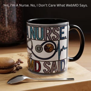 May include: White ceramic mug with a black interior and handle. The mug features the text "NURSE" and "I DON'T CARE WHAT WEBMD SAYS" with medical-themed graphics. A spoon and a macaron are in the foreground.