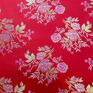 May include: Red fabric with a floral pattern in gold and pink. The fabric has a brocade texture. The text "东红色" is visible in the image.