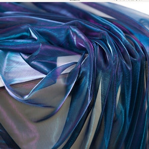 May include: A close-up of iridescent blue and purple mesh fabric. The fabric is sheer and has a metallic sheen.