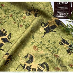 Może przedstawiać: Zielona tkanina z powtarzającym się wzorem czarnych koni, beżowych akcent&oacute;w i element&oacute;w kwiatowych. Tkanina ma teksturowany wygląd i estetykę vintage. Konie są przedstawione w stylizowanej, biegnącej pozie, z czerwonymi i beżowymi kwiatami.