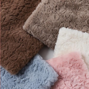 Puede incluir: Cinco muestras de tela de piel sintética de diferentes colores. Las muestras están dispuestas en círculo, con la muestra marrón en la parte superior, la muestra beige a la derecha, la muestra blanca en la parte inferior derecha, la muestra rosa en la parte inferior izquierda y la muestra azul a la izquierda.