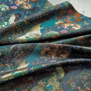 Puede incluir: Una tela doblada con un patr&oacute;n detallado y colorido. El dise&ntilde;o presenta una mezcla de tonos turquesa, dorado, marr&oacute;n y azul, con motivos florales y tipo paisley. La tela tiene un brillo lujoso, lo que sugiere un material de alta calidad.