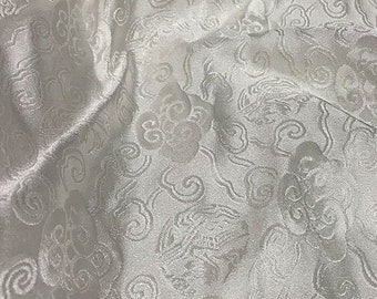May include: White fabric with a raised, embossed pattern of swirling clouds. The fabric has a subtle sheen and a soft texture.