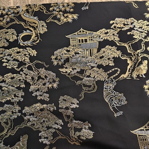 Può includere: Tessuto nero con un design asiatico dorato e argentato. Il motivo include un drago, tigri, pagode e alberi stilizzati. Il tessuto ha un aspetto strutturato.