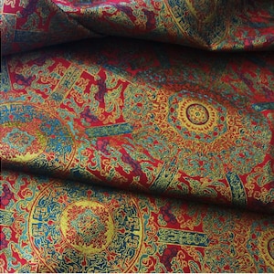 May include: Red fabric with a gold and blue patterned design. The pattern features intricate floral motifs and geometric shapes.