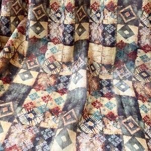 Peut inclure: Un tissu avec un motif géométrique dans des tons de brun, beige, bleu et rouge. Le motif est composé de carrés et de losanges.