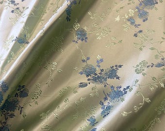 May include: A light green fabric with a blue and green floral pattern. The fabric has a subtle sheen and a soft texture. The text "牡丹小花" is visible in the bottom right corner of the image.