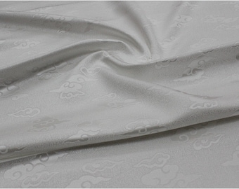 May include: White fabric with an embossed cloud pattern. The fabric is smooth and silky.