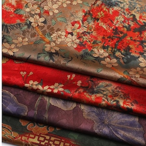 May include: A selection of fabric samples with floral designs. The fabrics display a range of colours, such as red, brown, and purple, with intricate patterns of flowers and foliage. The textures appear smooth and luxurious, suitable for various textile projects.