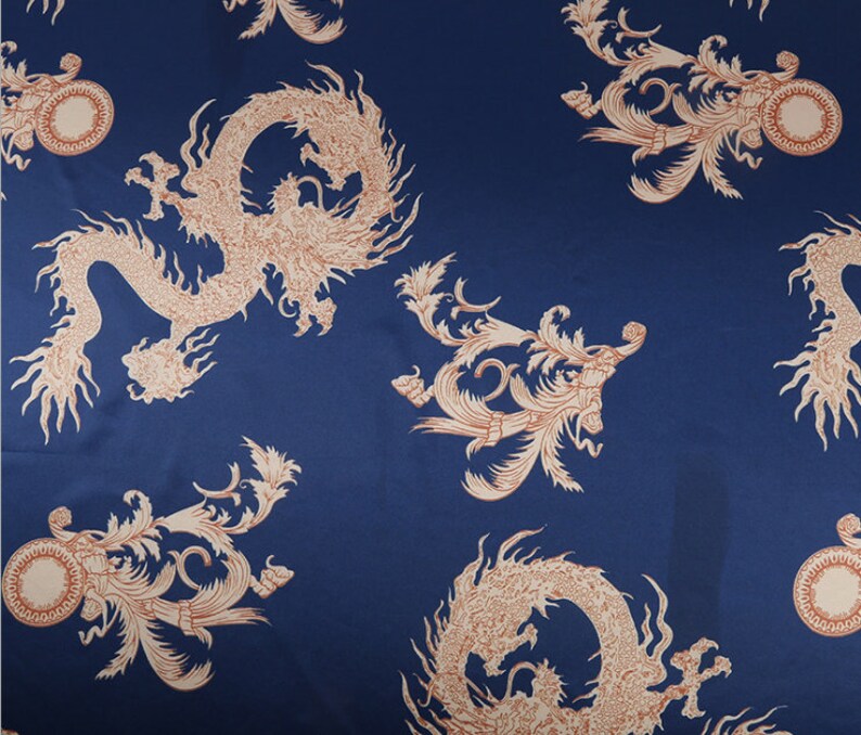 Peut inclure: Un tissu bleu marine avec un motif r&eacute;p&eacute;t&eacute; de dragons et de volutes d&eacute;coratives de couleur marron clair. Le motif pr&eacute;sente des illustrations d&eacute;taill&eacute;es de cr&eacute;atures mythiques et d'&eacute;l&eacute;ments floraux, cr&eacute;ant une esth&eacute;tique luxueuse.