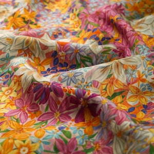 May include: A close-up of a fabric with a floral print. The fabric is a light beige color with a variety of flowers in shades of pink, yellow, orange, and blue.