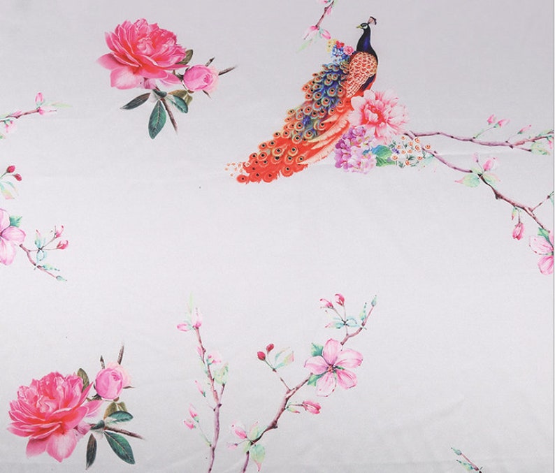 Peut inclure: Un tissu blanc avec un motif floral r&eacute;p&eacute;t&eacute; de pivoines roses et de fleurs de cerisier. Un paon avec des plumes orange, rouges et bleues est perch&eacute; sur une branche. Le motif a une esth&eacute;tique aquarelle.