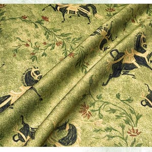 Może przedstawiać: Zielona tkanina z powtarzającym się wzorem czarnych koni ze złotymi akcentami, kwiatowymi pnączami i małymi czerwonymi kwiatami. Tkanina ma teksturowany wygląd i jest złożona, pokazując powtarzalność wzoru.