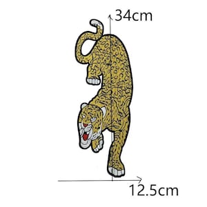 Può includere: Toppa ricamata con leopardo giallo e nero, misura 34 cm di altezza e 12,5 cm di larghezza. Il leopardo è raffigurato in posizione discendente con la bocca aperta, che rivela dettagli rossi. La toppa è progettata per l'applicazione su abbigliamento o accessori.