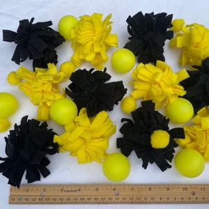 May include: A collection of yellow and black felt pom-poms and yellow balls. The pom-poms are made of soft, fluffy fabric and are ideal for sensory play or as a decorative element.