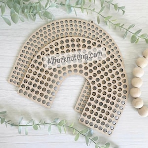 May include: Three wooden rainbow-shaped weaving looms with numerous small circular holes. The looms are light brown and arranged on a white surface with green foliage and wooden beads. The text "Allforknotting.com" is visible.