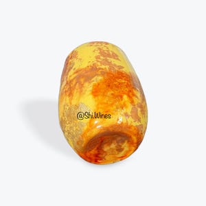 May include: A decorative, egg-shaped object with a glossy finish. The surface is a blend of yellow, orange, and brown hues, with gold accents. The text "@Shi.Wines" is visible on the side. The overall design suggests a unique, artistic piece.