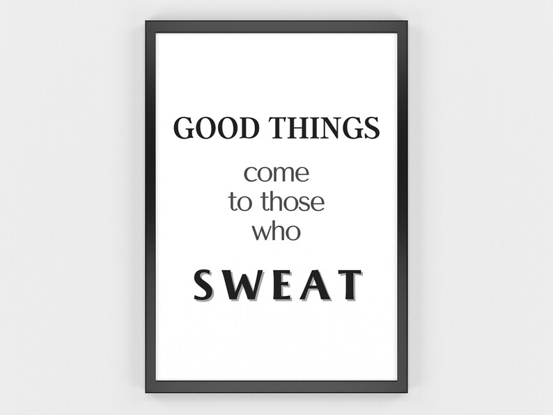 May include: A framed print with a white background and black text. The text reads "GOOD THINGS come to those who SWEAT." The frame is black. The print is a motivational piece for a home gym or fitness space.