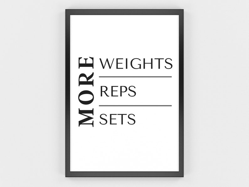 May include: A framed print with a white background and black text. The word "MORE" is vertically aligned on the left. The words "WEIGHTS", "REPS", and "SETS" are horizontally aligned on the right, separated by lines. The frame is black.