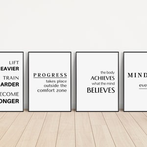 May include: Four framed motivational posters with black frames and white backgrounds. Each poster features black text with inspirational quotes about fitness and mindset. The quotes include "Lift Heavier, Train Harder, Become Stronger."