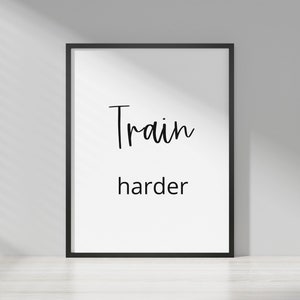 May include: A black framed motivational poster with white background and the text "Train harder" in black cursive font.