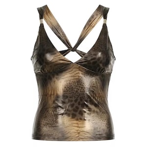 Puede incluir: Un top sin mangas de color marrón y dorado metálico con un diseño de tirantes cruzados y un estampado de leopardo.