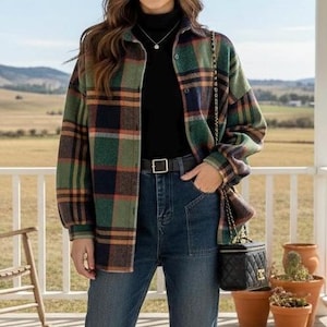 Peut inclure: Veste de chemise à carreaux verts, marine et orange, avec un col roulé noir et un jean bleu. Un sac à main noir avec une bandoulière en chaîne dorée est suspendu à l'épaule. La tenue est complétée par une ceinture noire avec une boucle argentée.