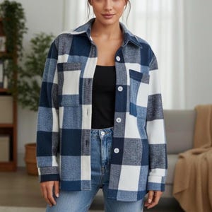 May include: A blue, white, and navy checked shirt jacket with a collared neckline and button-down closure. The jacket has two front pockets and is worn with blue jeans and a black top.