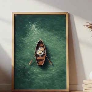 May include: A framed print of a wooden rowboat on a green body of water. The boat contains oars, a striped blanket, and a straw hat. The artwork is in a wooden frame and leans against a white wall.