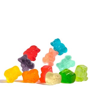 May include: A selection of multi-coloured gummy bear sweets. The gummy bears are in various colours, including red, orange, yellow, green, blue, purple, and peach, against a white background.