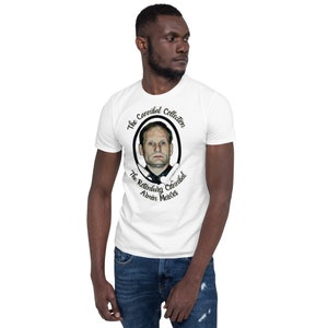 May include: White t-shirt with a black and white graphic of a man's face in a circle. The text "The Cannibal Collection" and "The Rotenburg Cannibal Armin Meiwes" is printed around the circle.