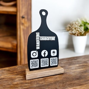 May include: Black chalkboard sign with a wooden base, featuring the text "Wandering Charcuterie" and social media icons with QR codes.