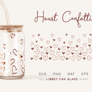 May include: A 16oz glass jar with a wooden lid and a straw, decorated with a pattern of gold and white hearts. The jar is labelled "LIBBEY CAN GLASS" and is surrounded by a scattering of red hearts. The text "Heart Confetti" is written in red at the top of the image.