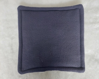 Peut inclure: Un coussin carré de couleur bleu foncé avec une texture douce et duveteuse.