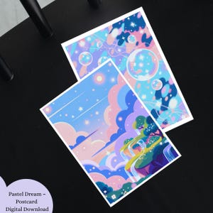 Puede incluir: Dos postales de colores pastel con ilustraciones de ensueño. Una presenta burbujas y estrellas en tonos azules y rosas. La otra representa un paisaje con una cascada, nubes y estrellas. Las postales están sobre una superficie negra.