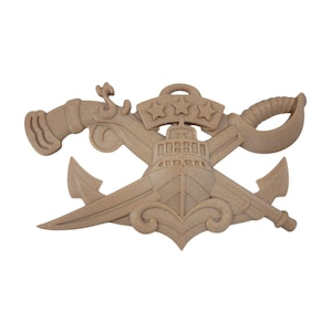 May include: A wooden nautical emblem featuring a ship, anchor, sword, cannon, and three stars. The emblem is light brown and has a detailed, carved design. The elements are arranged in a crossed pattern, suggesting a military or maritime theme.
