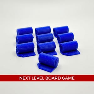 Peut inclure: Dix pièces de jeu en plastique bleu en forme de tapis enroulés. Les pièces sont disposées en quinconce sur une surface blanche.
