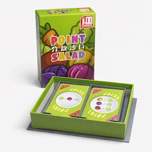 May include: A green box of the card game "Point Salad" with the box open to reveal the cards inside. The box has a colorful illustration of vegetables and the game title in English and Chinese.