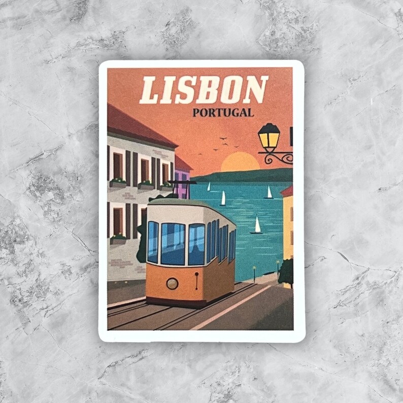May include: A vintage-style illustration of a yellow tram traveling up a hill in Lisbon, Portugal. The tram is in the foreground, with buildings and a sunset in the background. The text "LISBON PORTUGAL" is at the top of the image.