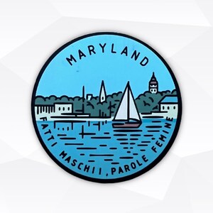 May include: A circular sticker featuring a light blue background with a stylized illustration of a sailboat on water, trees, and buildings. The text MARYLAND is arched at the top, and the text FATTI MASCHII, PAROLE FEMINE is arched at the bottom.