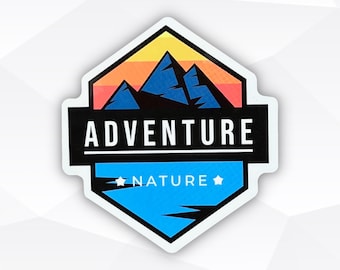 May include: A sticker with a mountain range design. The top portion features a sunset gradient of yellow, orange, and red. Below is a black banner with the word "ADVENTURE" in white. The bottom section is blue with the word "NATURE".