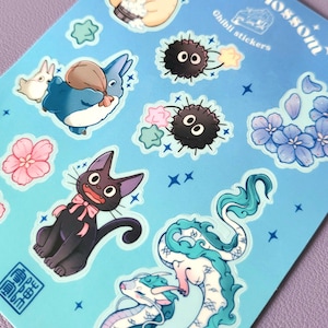 May include: A sheet of blue stickers featuring characters from Studio Ghibli films. The stickers include Totoro, No Face, Jiji the cat, and the dragons from Spirited Away. The stickers are surrounded by stars and flowers.